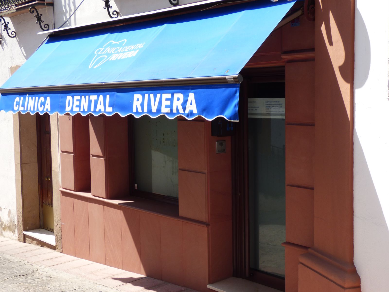 Fachada de Clínica Dental Rivera con su toldo azul